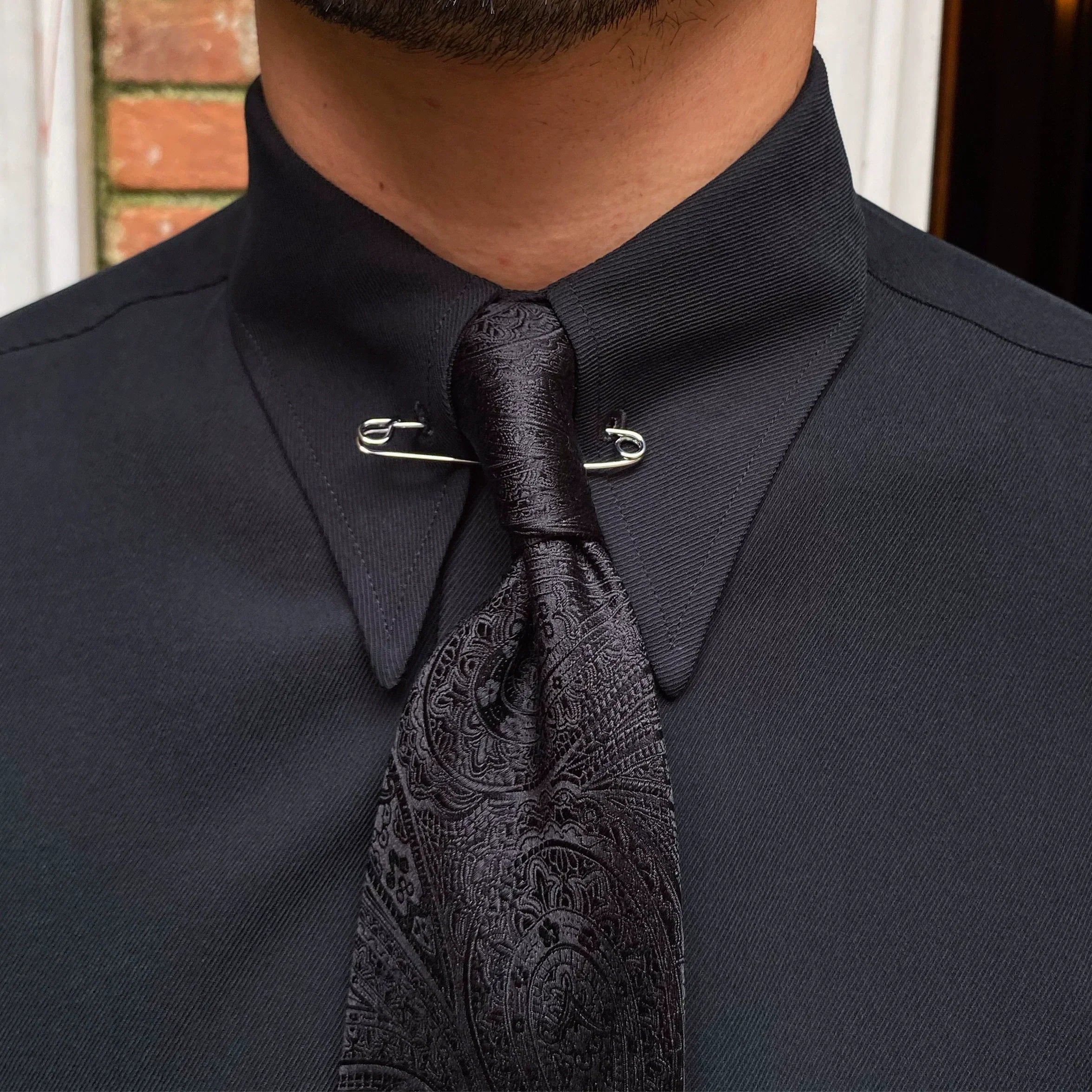 Camisa com colarinho pontiagudo e broche